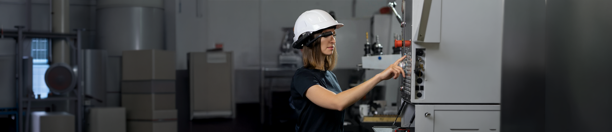 Technician wearing AR smart glasses while operating industrial equipment, representing augmented reality, hands-free maintenance, and Industry 4.0.